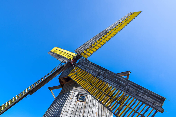 Старий, дерев'яний вітряк XIX століття, вид знизу на блакитне небо
 - Фото, зображення