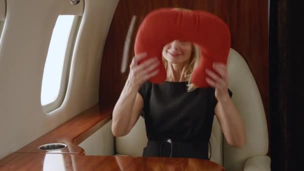 Beautiful rich mature woman using neck pillow while luxury journey in first business class airlines. - Footage, Video