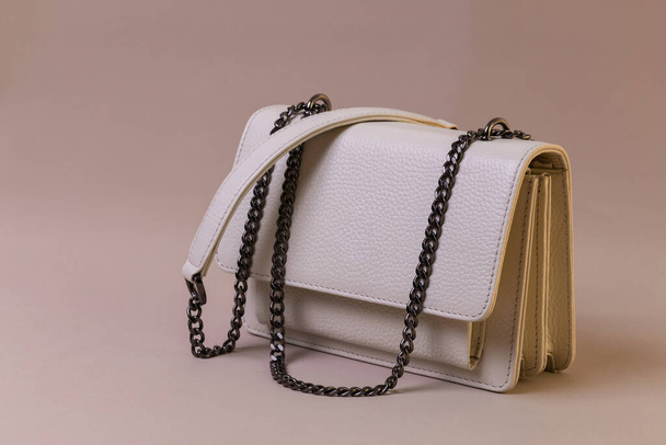 Beige leather handbag on fabric background. Fashion and shopping concept - Photo, Image