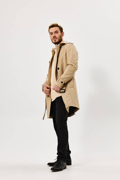 muž v béžové kabát móda moderní styl boční pohled plné délky - Fotografie, Obrázek