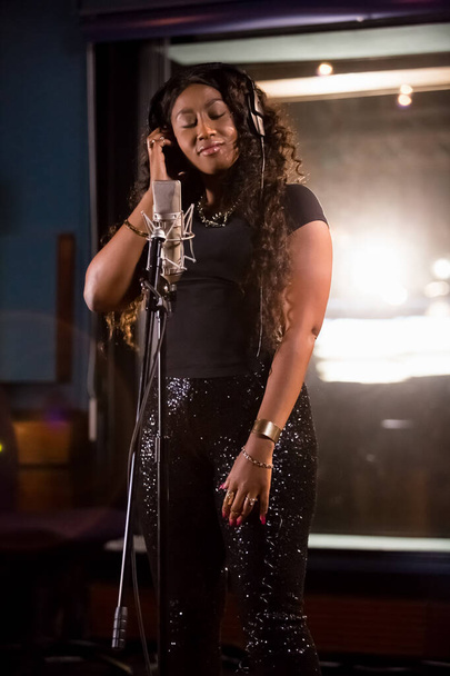 Johannesburg, South Africa - April 29, 2015: Victoria Kimani, Kenya singer recording vocal part on Afro-pop song in studio - Photo, Image