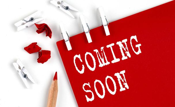 COMING SOON text on red paper with office tools on the white background - Photo, Image