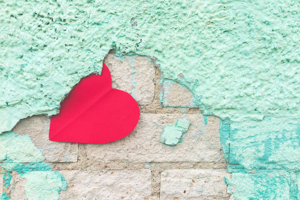 Ystävänpäivä tausta punainen paperi sydän maalaismainen vihreä mureneva wall.the sydän on juuttunut stukki. - Valokuva, kuva