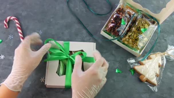 Mädchen wickelt Geschenkbox mit getrockneten Früchten Nüsse einzeln verpackt Set. Gesunde Ernährung. Weihnachtsfeier Feiertage Vorbereitung Öko natürlichen Snack in weiblichen Händen. Bewusster Konsum hausgemachte Süßigkeiten - Filmmaterial, Video