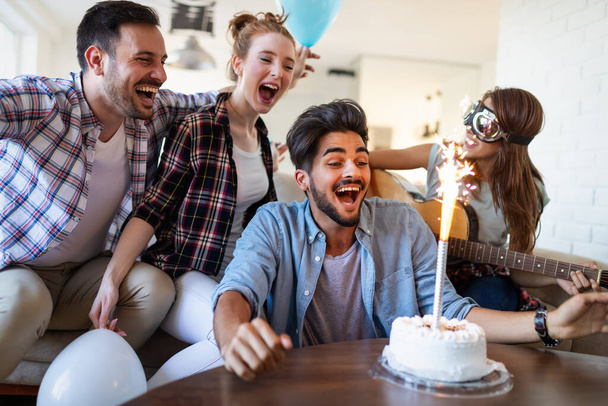 Group of happy friends celebrating birthday together at home - Foto, imagen