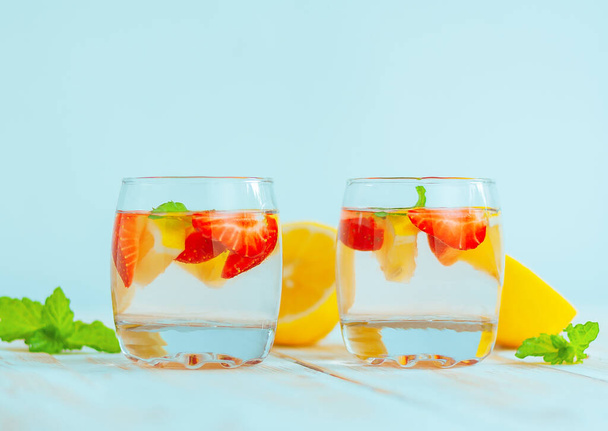 dois copos com uma bebida refrescante de verão feita de limão, morango e hortelã. água de limonada. citrinos e coquetel de baga. - Foto, Imagem
