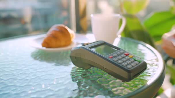 NFC luottokorttimaksu. Nainen maksaa kontaktittomalla luottokortilla NFC-tekniikalla kahvilassa. Langaton rahansiirto. Langaton maksu - Materiaali, video