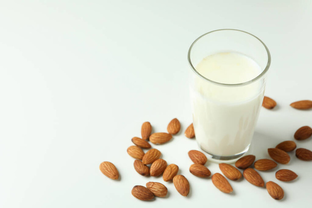 Glass of milk and almonds on white background - Fotó, kép