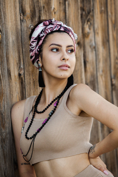 Portrait of a beautiful Indian girl in scarf. Young hippie style woman wearing handmade jewelry - Fotoğraf, Görsel