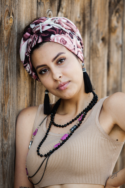 Portrait of a beautiful Indian girl in scarf. Young hippie style woman wearing handmade jewelry - Photo, Image