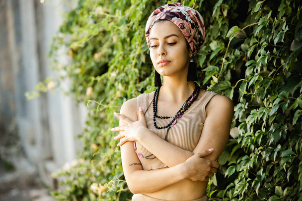 Portrait of a beautiful Indian girl in scarf. Young hippie style woman wearing handmade jewelry - Фото, зображення
