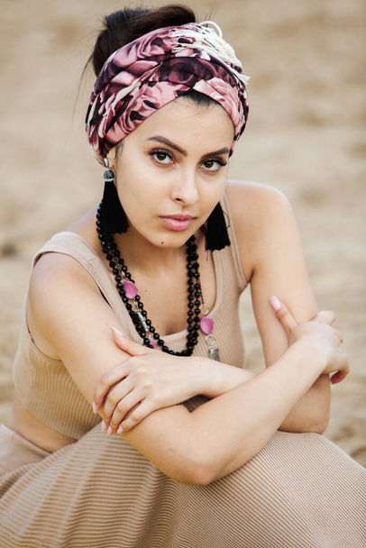 Portrait of a beautiful Indian girl in scarf. Young hippie style woman wearing handmade jewelry - Zdjęcie, obraz