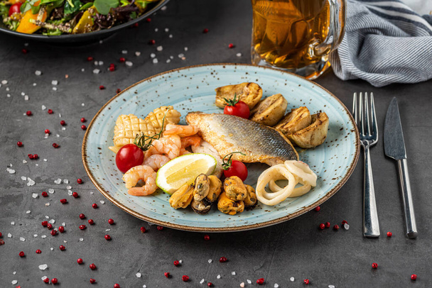 Πιάτο θαλασσινών ανάμεικτο με ψάρι, καλαμάρι, χταπόδι, μύδια και γαρίδες. - Φωτογραφία, εικόνα