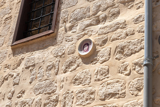 Dekorative Tafel mit dem Antlitz Jesu Christi und dem Vaterunser auf Russisch, die an der Wand der griechisch-orthodoxen St. Georges-Kathedrale in der Altstadt von Akko in Nordisrael angebracht ist - Foto, Bild