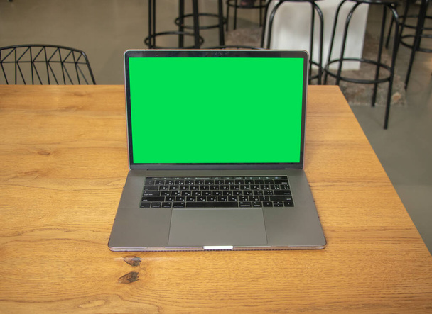 Laptop with green screen. Background. Green screen. Mockup. Laptop on table - Foto, Imagem