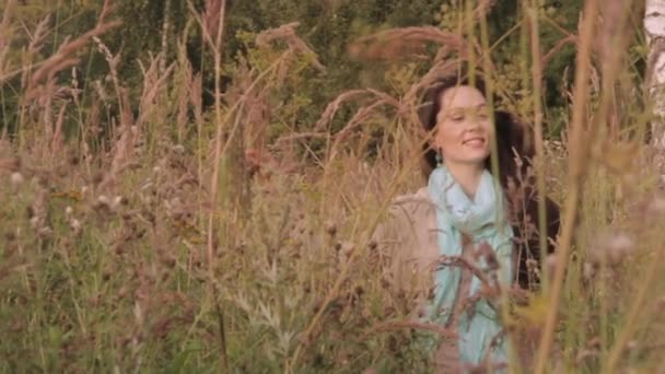 フィールド草の中を歩く幸せと楽しい若い女性.  - 映像、動画