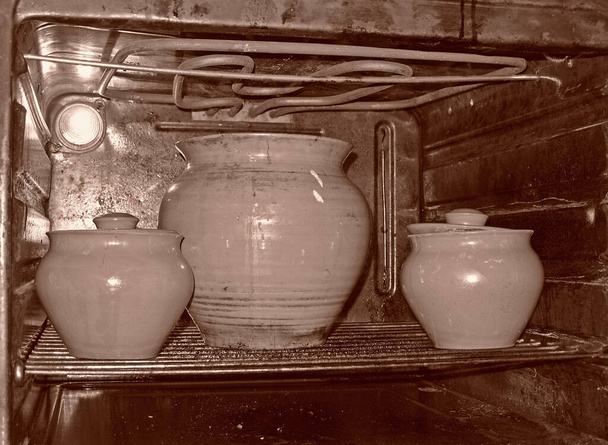 Panelas de cerâmica em um forno elétrico aberto e sujo - Foto, Imagem