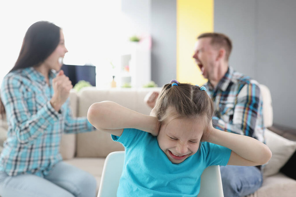 Little girl closing her ears against background of swearing parents at home - Fotoğraf, Görsel