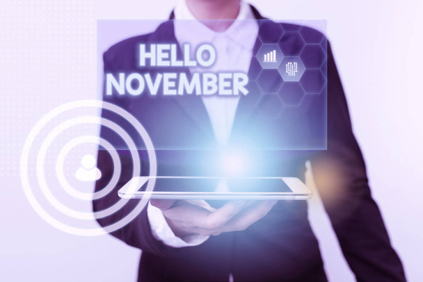 Kirjoitetaan tekstiä Hello November. Business lähestymistapa tervehdys käytetään, kun toivottaa tervetulleeksi yhdentenätoista kuukautena nainen puvussa Seisova Laite Näytetään uusia Futuristic Virtual Tech. - Valokuva, kuva