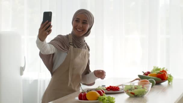 Blogger musulmán Señora haciendo video receta de cocina en la cocina - Imágenes, Vídeo
