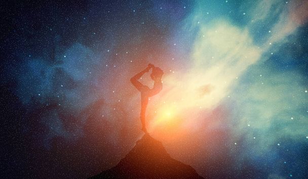 Žena v józe představuje meditaci na pozadí galaxie mlhovin. Zen, pohoda a péče o tělo - Fotografie, Obrázek