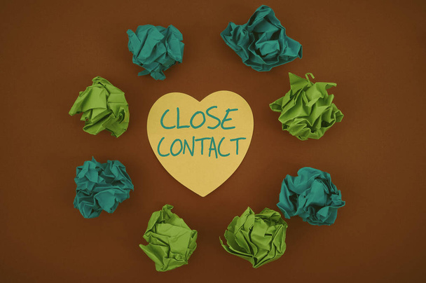 Podpis koncepcyjny Close Contact. Koncepcja Internetu o historii bezpośredniego kontaktu z pacjentem z chorobą Kolorowe pogniecione papiery Okrągły wzór Otaczające serce w kształcie karty. - Zdjęcie, obraz