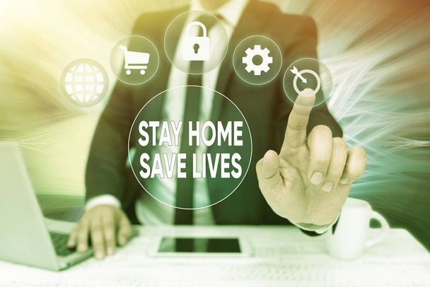 Bildunterschrift: Stay Home Save Lives. Word Geschriebene auf verringern die Anzahl der infizierten Patienten, indem sie das Haus nicht verlassen Bussiness Man Sitting Desk Laptop And Phone Pointing Futuristic Technology - Foto, Bild