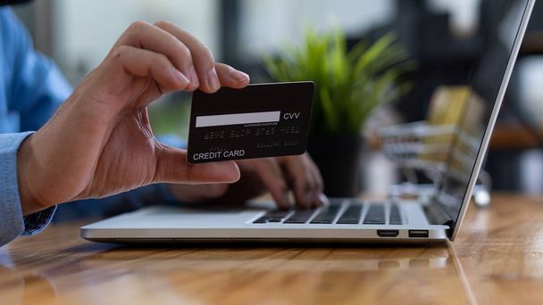 πιστωτική κάρτα πληκτρολογώντας στο πληκτρολόγιο laptop Concept των online αγορών και την πληρωμή μέσω των τραπεζών internet. - Φωτογραφία, εικόνα