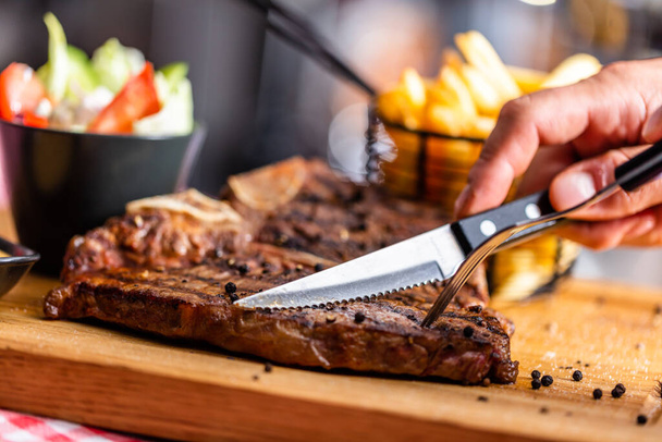 Rindersteak mit Messer in amerikanischem Restaurant geschnitten - Foto, Bild