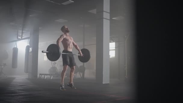 A young male weightlifter lifts a heavy barbell over his head performing a jerk. the jerk of a heavy barbell in slow motion - Footage, Video