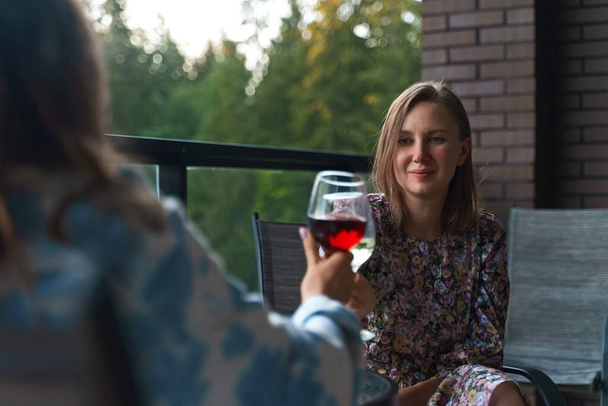 Dois amigos estão bebendo vinho na varanda de férias. - Foto, Imagem
