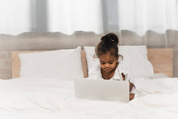 szczęśliwy Afryki amerykański maluch dziecko za pomocą laptopa w sypialni - Zdjęcie, obraz