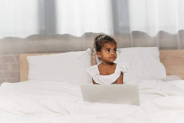 toddler african american kid using laptop in bedroom - Foto, imagen