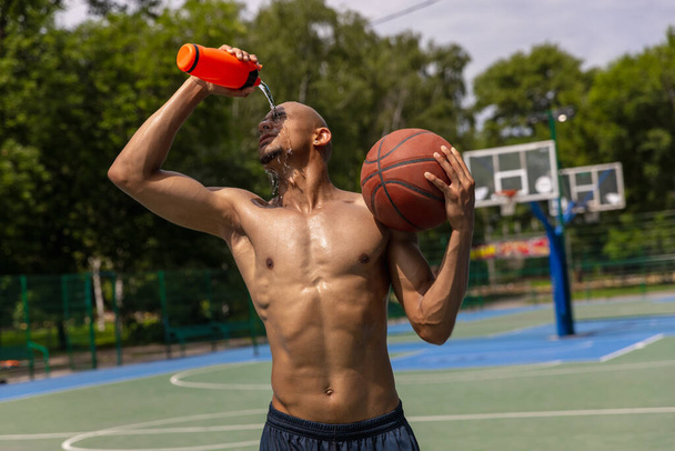 Young strong man, male basketball player training at street public stadium, sport court or palyground outdoors. Concept of healthy active lifestyle, motion, hobby. - Foto, Imagem