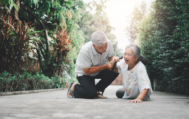 Asiatische Seniorin fiel zu Hause auf den Boden, nachdem sie vor der Haustür gestolpert und vor Schmerzen geweint hatte, und ihr Mann kam, um zu helfen. Konzept der Alten- und Pflegeversicherung - Foto, Bild