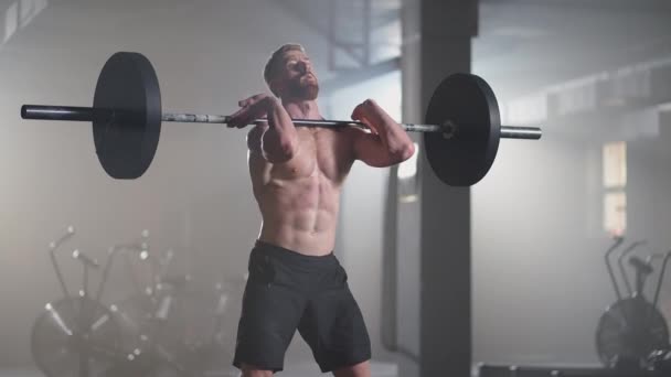 Lassú mozgás: fitness férfi testépítő edzés segítségével súlyemelő edzés izmos sportoló erő emelés nehéz súly csinál guggolás tornaterem gyakorlat élvezi az egészséges életmód - Felvétel, videó