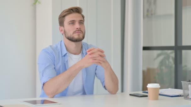 Pensive jonge creatieve man zitten in kantoor denken  - Video