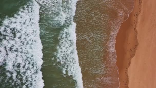 Filmagem aérea de uma praia vazia em Lagos, Portugal. O tiro do drone da vista do olho das aves mostra uma vista larga das ondas grandes e de um oceano turquesa. - Filmagem, Vídeo