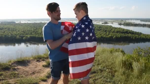 Carino giovane ragazzo e suo padre tenendo in alto la bandiera americana - Filmati, video