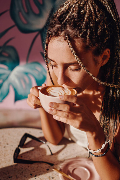Closeup shot of woman in cafe drinking capuccino - Фото, изображение