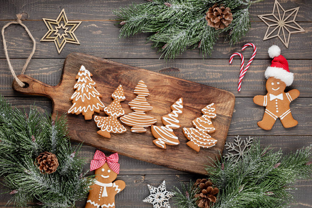 Tasty gingerbread cookies and Christmas decor on wooden background. - Foto, Imagen