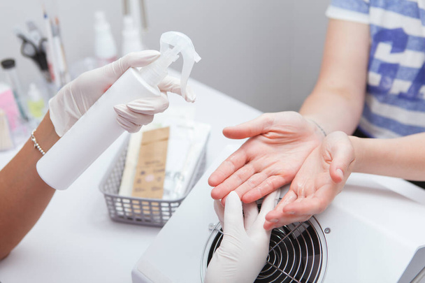 Unrecognizable female client having her hands disinfected before manicure at the salon - Foto, Imagem