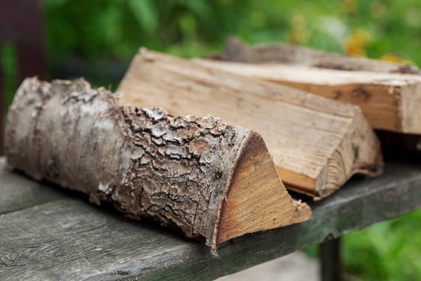 Logs of firewood lie on a bench in the street. Close-up. Picnic in nature. - Foto, Bild