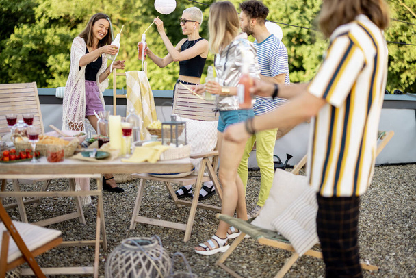 Mladí styloví přátelé mají slavnostní večeři na střešní terase - Fotografie, Obrázek