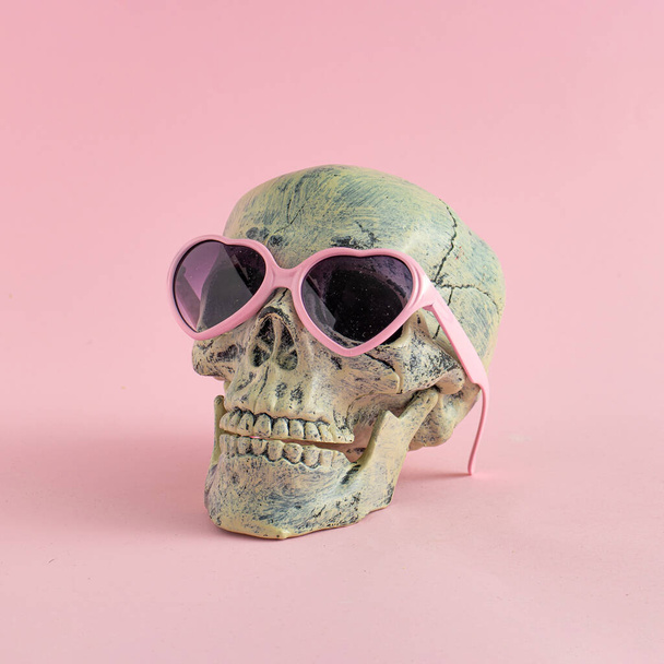 Skull with glasses on pink background. Halloween creative fashio - Foto, imagen