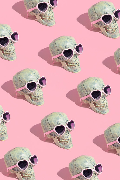 Skull pattern with glasses on pink background. Halloween creative fashion love concept. - Foto, afbeelding