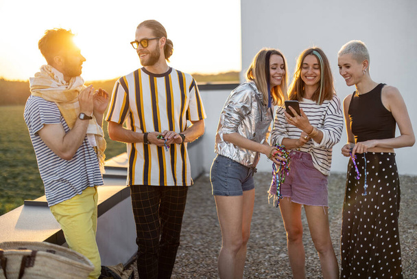 Jovens amigos saem no terraço no pôr-do-sol - Foto, Imagem