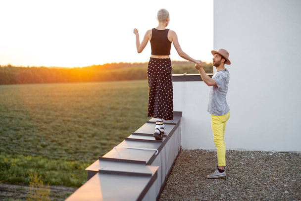 Couple marcher sur le toit au coucher du soleil - Photo, image