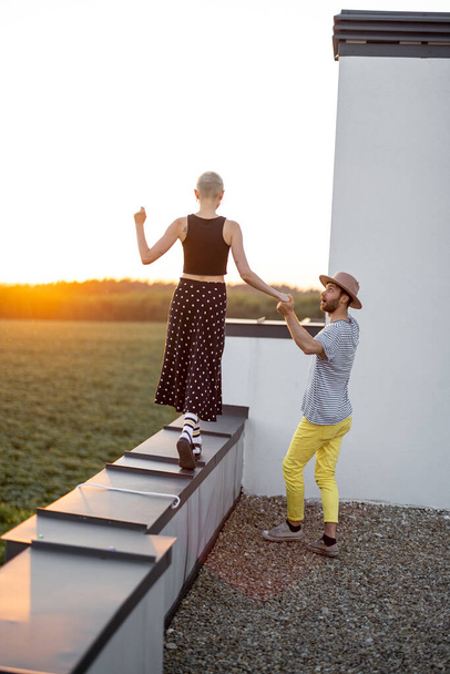 Couple walk on the rooftop at sunset - Foto, afbeelding