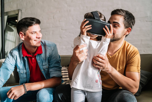 Gay couple and their kids playing video games with VR glasses. - Fotografie, Obrázek